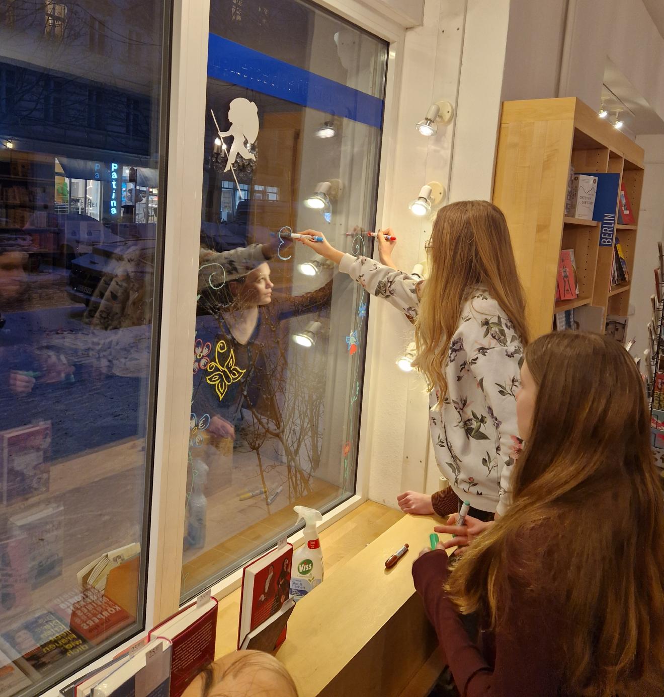 Die Leseclubkinder bemalen unsere Schaufensterscheibe